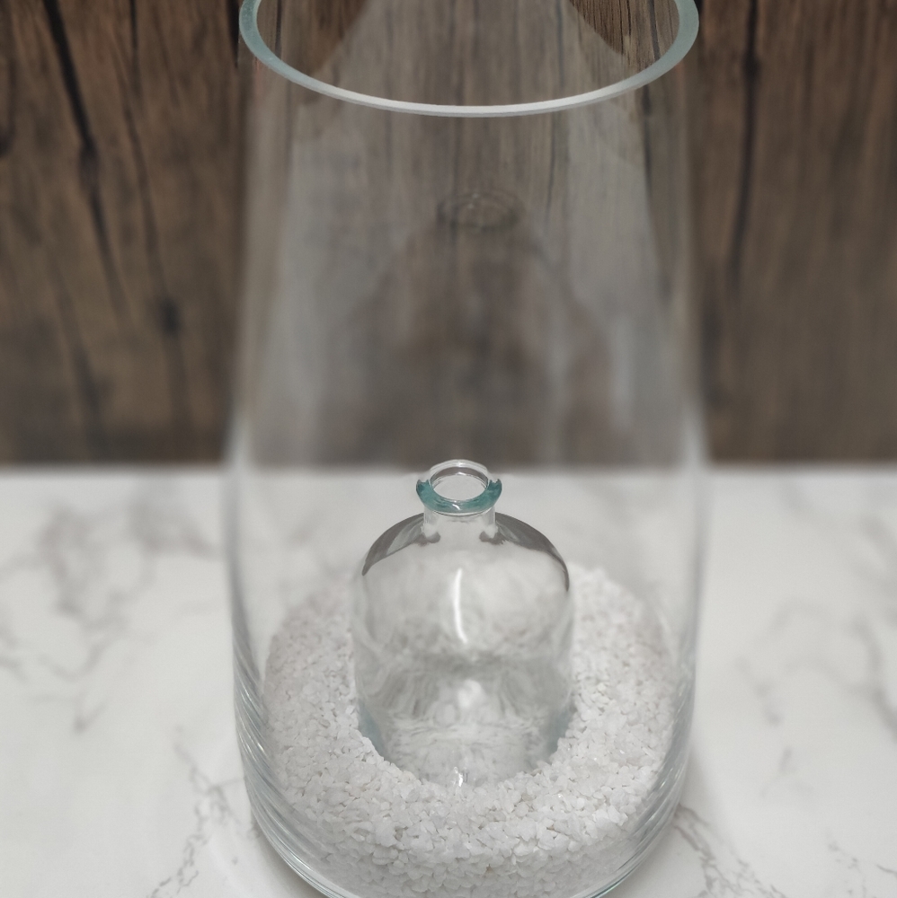 GLASS VASE WITH WHITE ROCKS. SMALL GLASS INSERTED IN MIDDLE OF VASE.